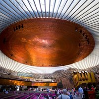 Temppeliaukion kirkon kuparinen sisäkatto ja kirkossa vierailevia turisteja.