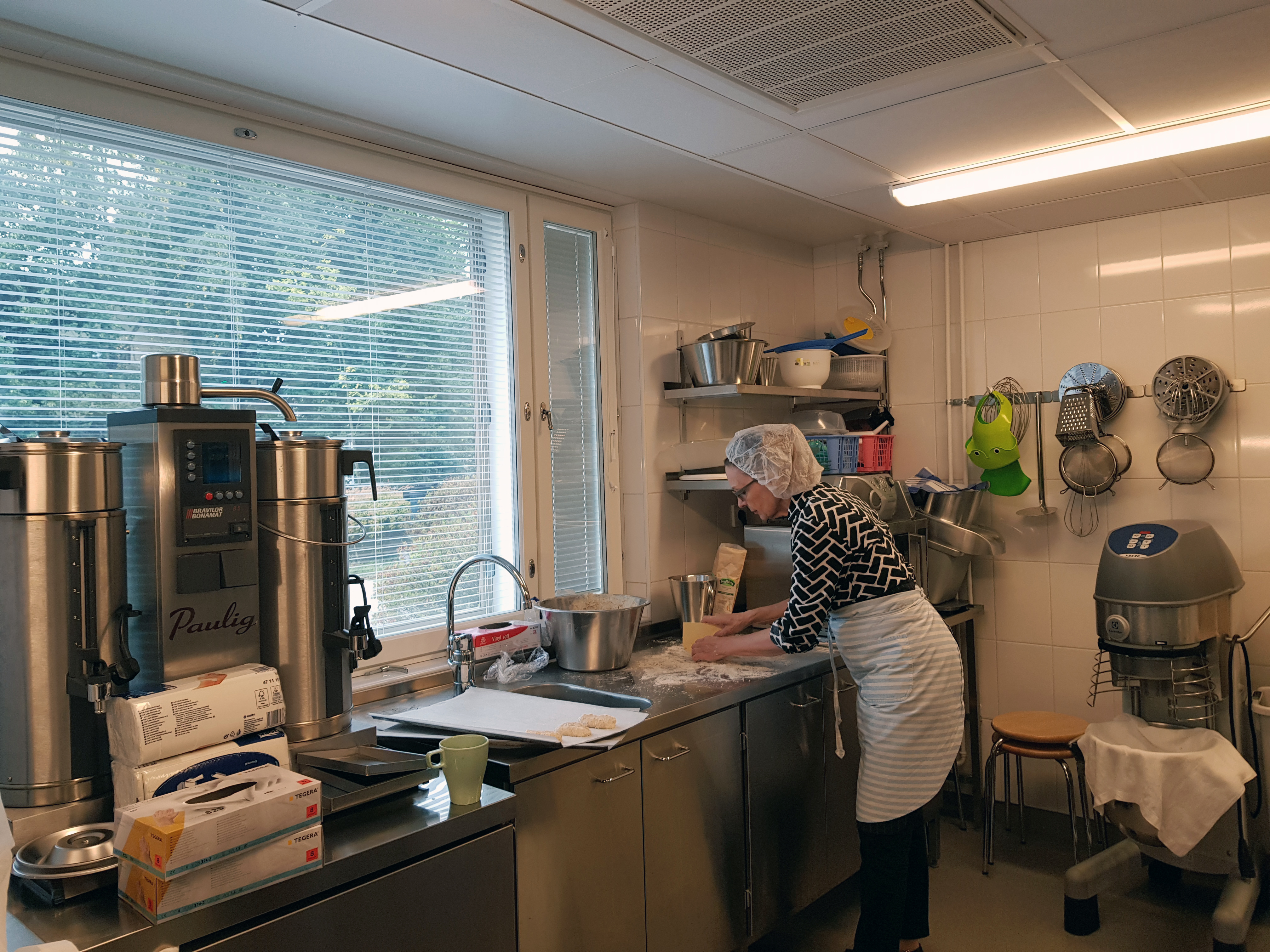 Suntio Eeva-Liisa Sammela leipomassa sämpylöitä keittiössä Ruskeasuon seurakuntakeskus Rastilla.