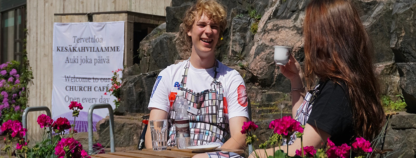 Temppeliaukion kirkon kesäkahvilan kahvilatyöntekijöitä terassikahvilla ulkona kirkon pihalla. Taustalla nä...