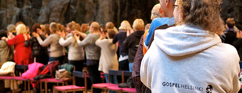 Gospelia kaikille Mass Choirin laulajia letkajenkkajonossa Temppeliaukion kirkossa.